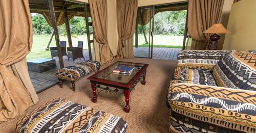 a living room with two couches and a table at Premier Resort Mpongo Private Game Reserve in Macleantown