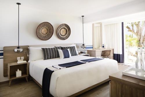 
a bedroom with a large bed and a clock on the wall at LUX* Grand Gaube Resort & Villas in Grande Gaube
