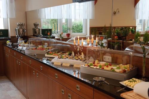a buffet line with several plates of food at Stadthotel Stern in Wismar