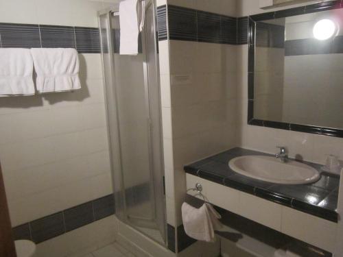 een badkamer met een wastafel en een douche bij La Taverne in Uzès