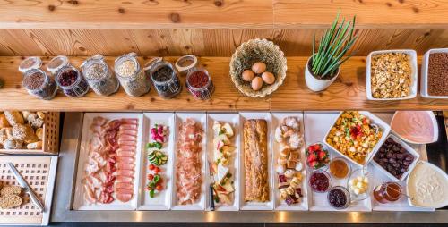 a display of different types of food on a shelf at Hotel Lener in Vipiteno