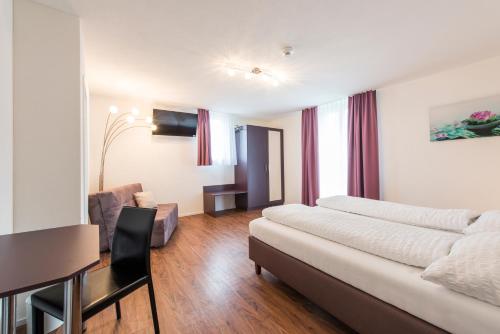 a living room with a bed and a table and a couch at Hotel Engel in Emmetten