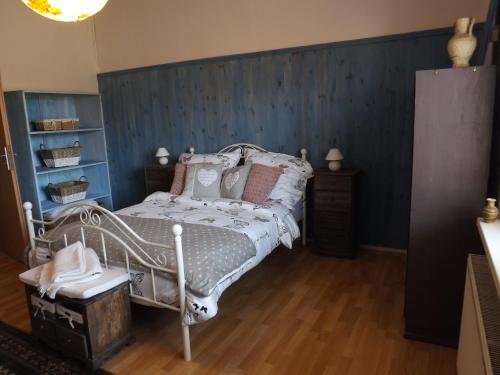 a bedroom with a bed and a blue wall at Studniska Country Estate in Studniska