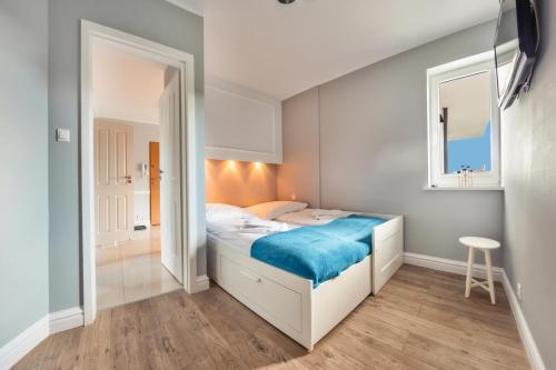 a small bedroom with a bed and a mirror at Hel Żeromskiego, Sun & Snow in Hel