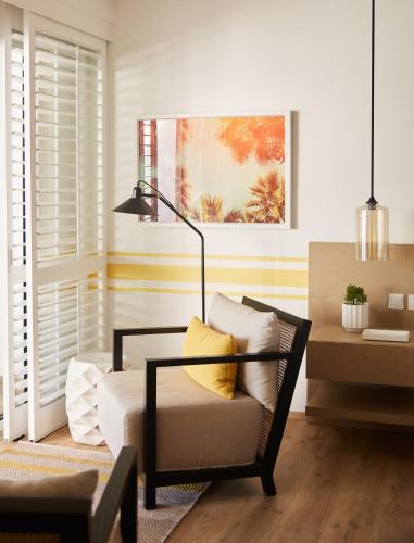 a living room with a chair and a lamp at LUX* Grand Gaube Resort & Villas in Grand Gaube
