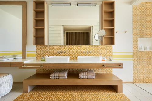 a bathroom with two sinks and a mirror at LUX* Grand Gaube Resort & Villas in Grand Gaube