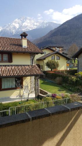 a house with a fence in front of it with mountains at A due passi dalla spiaggia in Colico