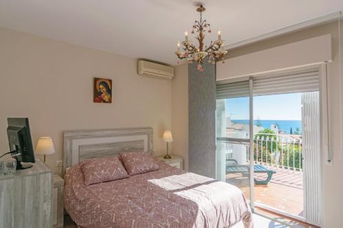 a bedroom with a bed and a balcony at Cubo's Villa Marieli Chilches in Chilches