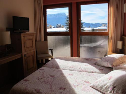 a bedroom with a bed and a window with a view at Hotel Alda A Boira in Jaca