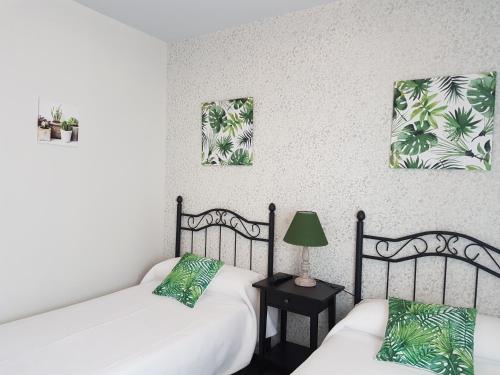 two beds in a room with green and white at Pension Amarantos in Suances