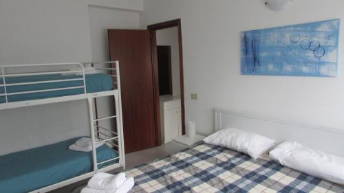 a bedroom with two bunk beds and a mirror at Appartamento Spiaggia Playa in Castellammare del Golfo