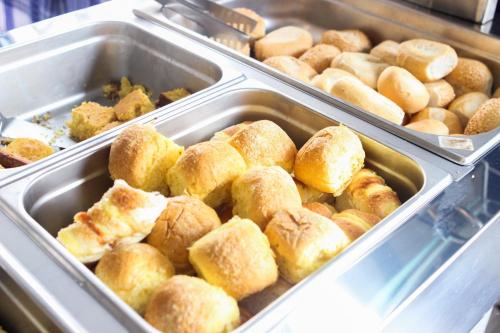 un montón de donuts en bandejas en una panadería en Hotel Diamantina - By UP Hotel - em Guarapari en Guarapari