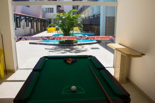 a pool table in a room next to a window at Hotel Diamantina - em Guarapari in Guarapari