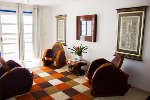 a living room with two chairs and a rug at Hotel Diamantina - em Guarapari in Guarapari