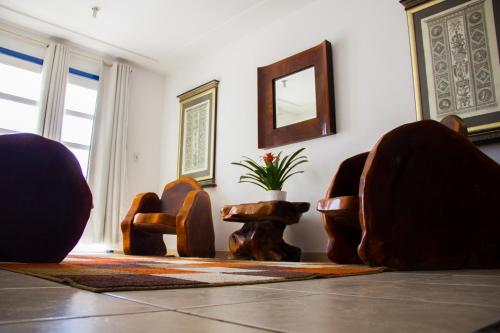 a living room with chairs and a mirror at Hotel Diamantina - em Guarapari in Guarapari