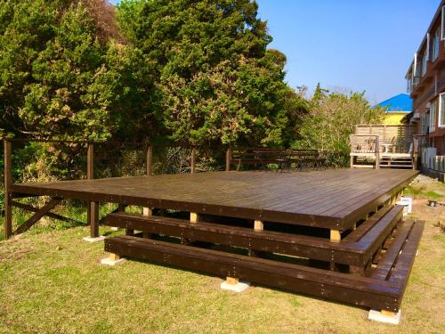 a large wooden picnic table sitting in the grass at Oli Oli Guesthouse in Shimoda
