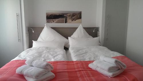 two towels sitting on top of a bed with pillows at dat geele hus Wohnung Nr. 4 in Büsum