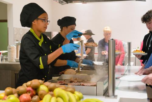 a group of people preparing food in a kitchen at Apartamentos Santa Rosa in Costa Teguise