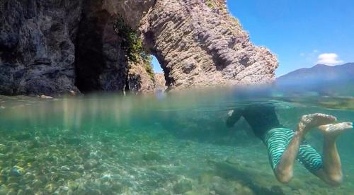 a person swimming in a body of water at Oli Oli Guesthouse in Shimoda
