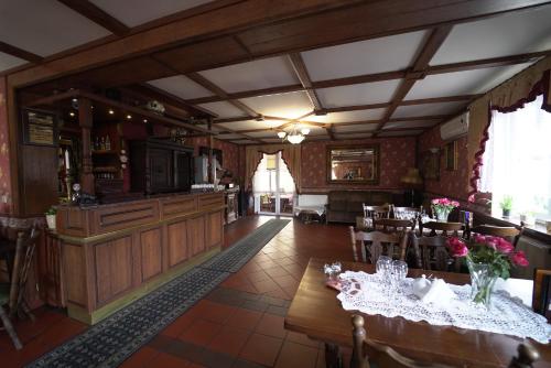 a dining room with a table and a bar at Dworek Biała Dama in Nieborów