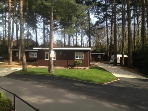a small house in the middle of a driveway at California Chalet & Touring Park in Wokingham