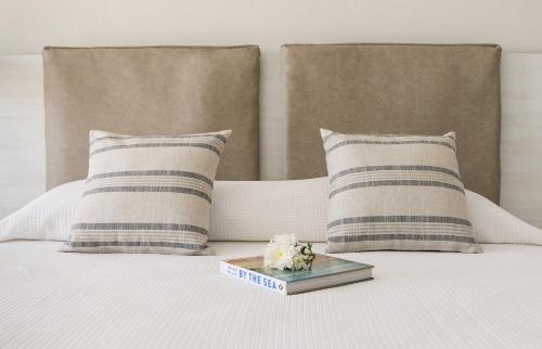 a bed with two pillows and a tray of flowers on it at Louis Paphos Breeze in Paphos City