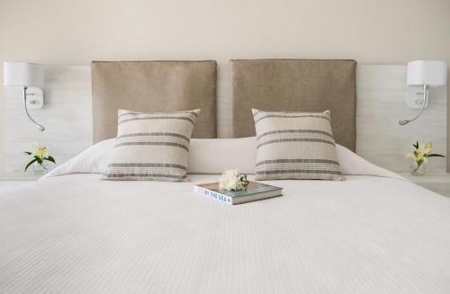 a white bed with two pillows and a tray on it at Louis Paphos Breeze in Paphos City