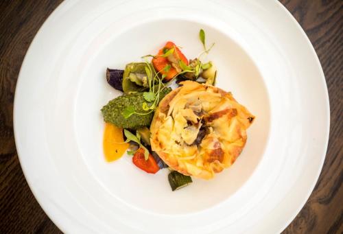 a white plate of food with vegetables on a table at Woodlands Lodge Hotel in Bartley