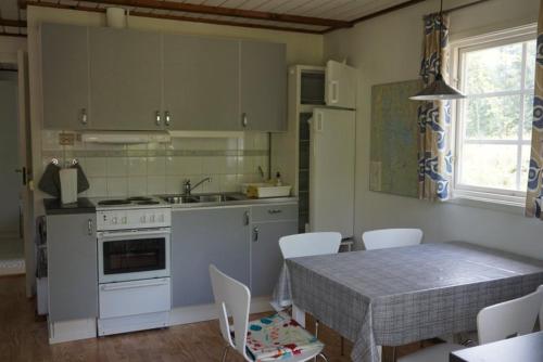 uma cozinha com uma mesa e uma mesa e cadeiras em Hunnebo em Lönashult