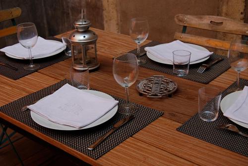- une table en bois avec des assiettes blanches et des verres à vin dans l'établissement Authentic Flat in Dijon, à Dijon