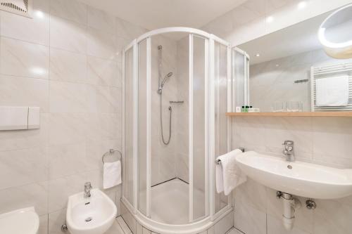 a bathroom with a shower and a toilet and a sink at Residence Hotel Gasser in Bressanone