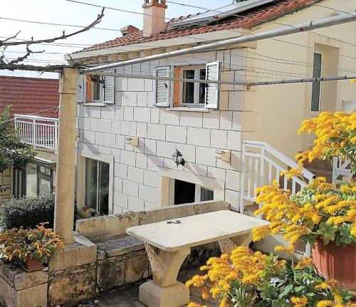 a picnic table in front of a house at Apartments Barbaresko in Lumbarda