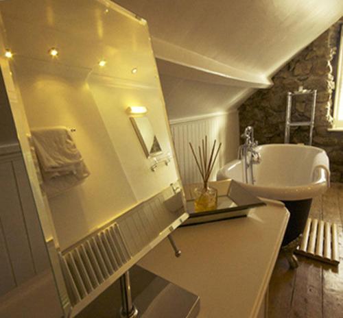 een badkamer met een wastafel en een bad bij Headland House Luxury B&B in St Ives