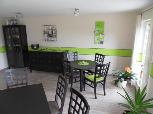 a dining room with a table and chairs and green stripes at FeWo/GZ Hannelore Müller in Leienfels
