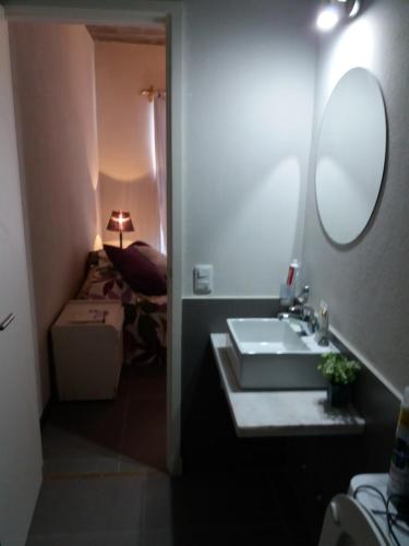 baño con lavabo, espejo y cama en Bikini Apartament, en Punta del Este