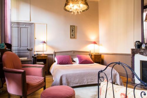 une chambre avec un lit avec des oreillers roses et une chaise dans l'établissement Authentic Flat in Dijon, à Dijon