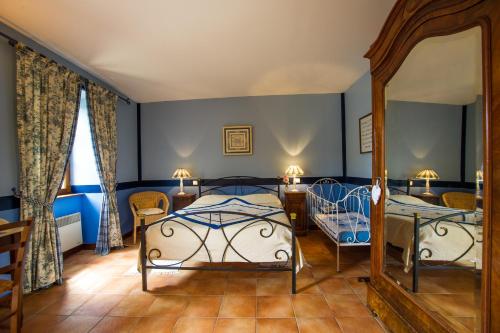 a bedroom with two beds and a mirror at Chez annie et jean michel Bagatelle chambres d hôtes in Châteauneuf