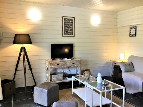 a living room with a tv and a couch and a table at Studio La Voile Blanche in Orient Bay French St Martin