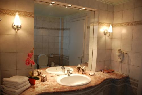 a bathroom with a sink and a large mirror at Hotel Pella in Giannitsa