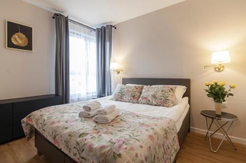 - une chambre avec un lit et 2 serviettes dans l'établissement Apartment Royal V, à Białystok
