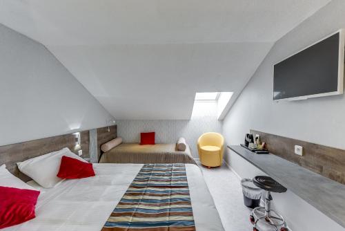 a bedroom with a bed and a tv on the wall at The Originals Access, Hotel Thouars in Thouars
