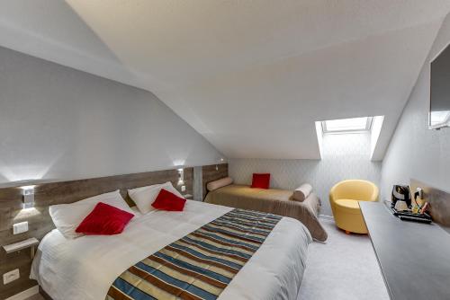 a bedroom with a large bed with red pillows at The Originals Access, Hotel Thouars in Thouars