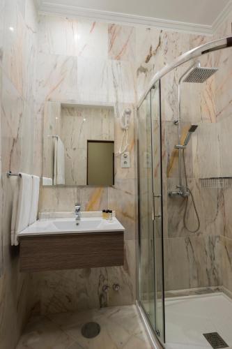 a bathroom with a sink and a shower at Hotel Internacional Porto in Porto