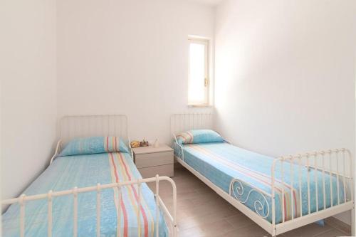 1 dormitorio con 2 camas y ventana en Casina degli Oleandri, en Lido Marini