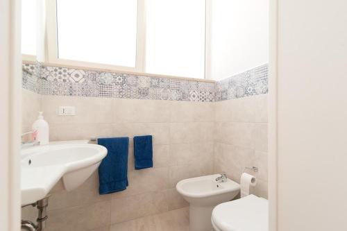 Baño blanco con lavabo y aseo en Casina degli Oleandri, en Lido Marini