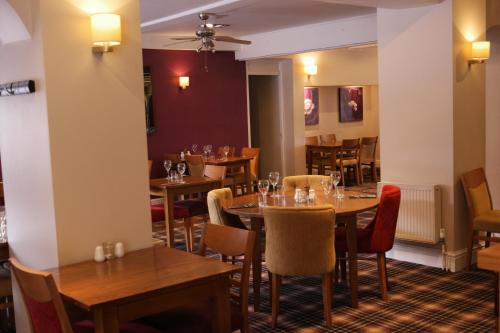 a dining room with wooden tables and chairs at The White House Hotel in Telford