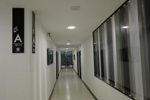 a hallway of a building with white walls and a sign at At Sakon Hotel in Sakon Nakhon