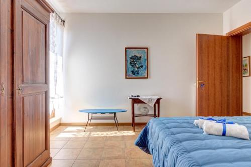 Finestra su Lucignano في لوسيغنانو: غرفة نوم بسرير ازرق وطاولة