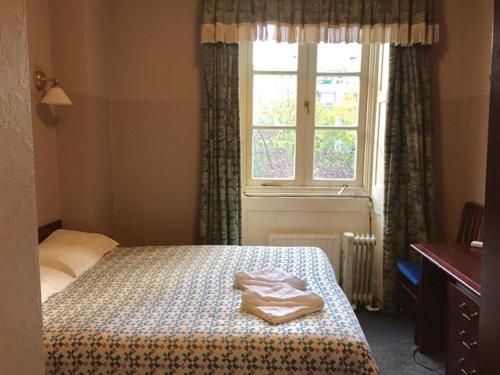 a bedroom with a bed and a window at Four Stars Hotel in London