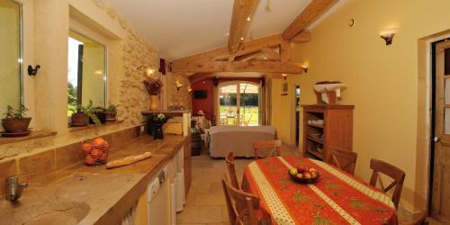 a kitchen with a table and a dining room at Gîtes Domaine des Machottes in Grans